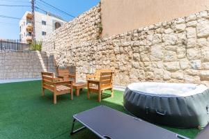 a patio with a table and a tire and chairs at Echo 1-BR Apartment In Ejdabra Batroun 