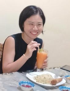 a woman sitting at a table with a drink at Hello Super Hostel in Ella