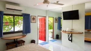a bedroom with a red door and a tv at Tea Moon Boutique Stay in Thong Sala