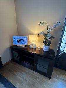 a desk with a computer and flowers on it at Casa dos Acevedo in Verín