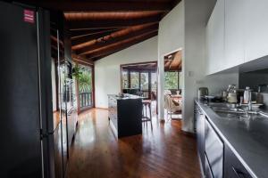 a kitchen with a counter and a dining room at The Graceful Dodeca Treehouse Coalcliff 