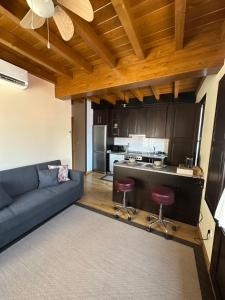 a living room with a blue couch and a kitchen at Casa dos Acevedo in Verín
