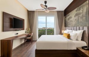 a bedroom with a bed and a desk and a television at Oraka by My Downtown Aura Hotel in Udaipur +22 photos