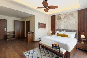 a bedroom with a large white bed and a ceiling fan at Oraka by My Downtown Aura Hotel in Udaipur