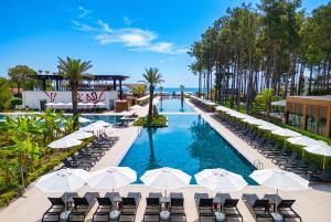 a pool with chairs and umbrellas at a resort at Siu Collection - Ultra All Inclusive in Beldibi +58 photos