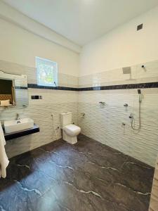 a bathroom with a toilet and a sink at Skylurk Transit in Negombo +2 photos