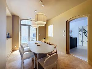 a dining room with a white table and chairs at Les Henrions in Pierrelatte