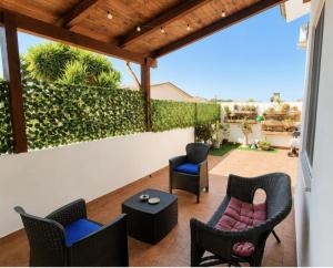 a patio with chairs and tables and a fence at Lello's Dream House in Càbras
