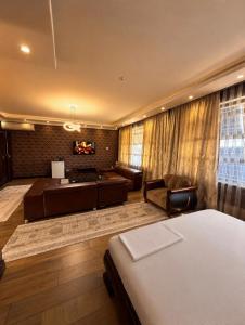 a bedroom with a bed and a living room with a couch at Seoul Hotel in Shymkent