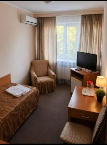 a hotel room with a bed and a chair at Гостиница ИЛЕК in Aktobe