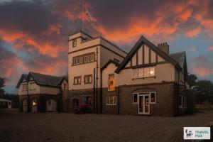 a building with a flag on top of it at The Plas - Rhosneigr Manor House in Rhosneigr