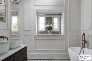 a white bathroom with two sinks and a tub at The Plas - Rhosneigr Manor House in Rhosneigr +45 photos