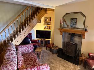 a living room with a couch and a fireplace at Ballygown Cottage in Torpys Cross Roads