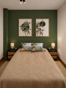 a bedroom with a large bed with green walls at Pretty House in Słupsk