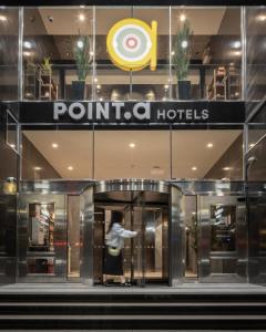 a person walking into the entrance to a point a hotel at Point A Hotel Edinburgh St Andrew Square in Edinburgh