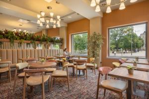 a restaurant with tables and chairs and a window at Point A Hotel Edinburgh St Andrew Square in Edinburgh