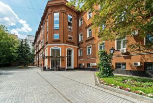 ein Backsteingebäude mit einem Uhrturm auf einer Straße in der Unterkunft Bagration Hotel in Moskau