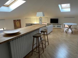 a kitchen and living room with a bar and stools at Laffittacamere Franciacorta in Passirano +3 photos