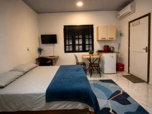 a bedroom with a bed and a kitchen with a table at Suite 02 in Barcarena