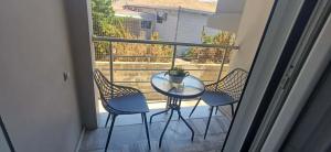 a table with chairs and a potted plant on a balcony at Modern apartment in Thérissos