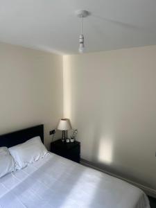a bedroom with a bed and a lamp on a table at Double Room Private Bathroom Parking South Croydon in Addington