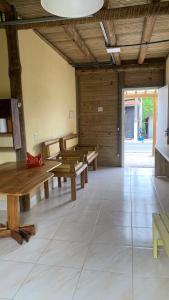 a room with wooden tables and benches in a building at Casa da Raposa in Iguaíba