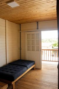 a large black bench in a room with a door at Casa da Raposa in Iguaíba