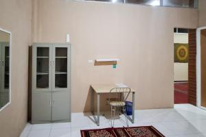 a room with a table and a chair next to a door at RedDoorz at Pasifik Hotel Sabang Aceh in Sabang