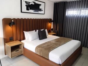 a bedroom with a large bed with a wooden headboard at The Spear Guest Lodge in Graskop