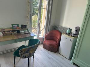 a room with a chair and a desk and a red chair at Sérénité in Saint-Vivien-de-Blaye