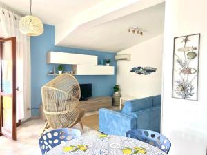 a living room with blue walls and a table and chairs at Casa Cucchiara in Bagnara Calabra