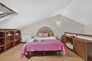 a bedroom with a large bed with a pink blanket at Casa da Abegoaria in Caniço