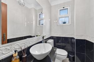 a bathroom with a white toilet and a sink at Casa da Abegoaria in Caniço +28 photos
