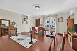 a living room with a table and a dining room at Casa da Abegoaria in Caniço