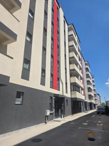 a building with a red stripe on the side of it at Elegant & cozy NeSt in Chiajna