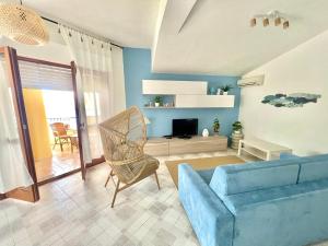 a living room with a blue couch and a television at Casa Cucchiara in Bagnara Calabra