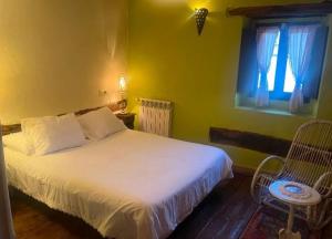 a bedroom with a white bed and a window at Urbasako Argizar Etxea in Larraona