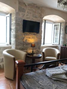 a living room with a tv on a stone wall at Villa Old Mariner in Kotor