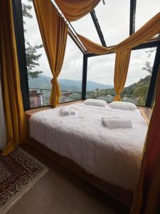 a bed in a room with a large window at Merisi - Sunset Chalet in Merisi +5 photos