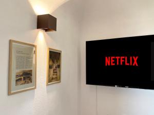 a tv on a wall with a netflix sign on it at Tiny House nel cuore del Monferrato in Conzano