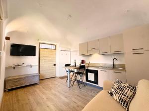 a kitchen with white cabinets and a table in a room at Tiny House nel cuore del Monferrato in Conzano