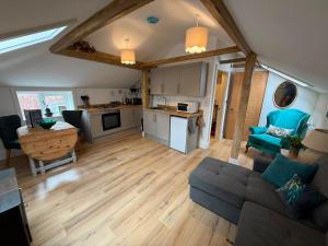 an open living room with a couch and a kitchen at The Music Rooms in Bewdley