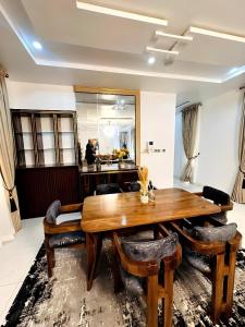 a dining room with a wooden table and chairs at Julaz Apartment in Lagos