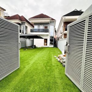 a yard with green grass between two buildings at Julaz Apartment in Lagos