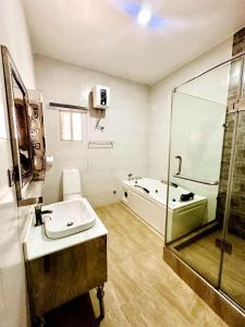 a bathroom with a tub and a sink and a shower at Julaz Apartment in Lagos +31 photos