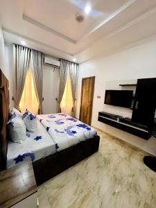 a bedroom with a bed and a flat screen tv at Julaz Apartment in Lagos
