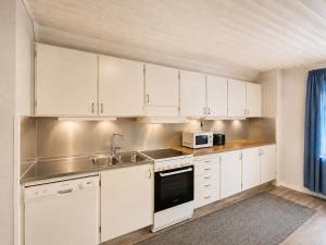 a kitchen with white cabinets and a sink and a microwave at Stilla Hem 2 in Tranemo
