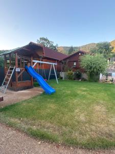 a playground with a blue slide in a yard at Chata u Zajpta in Ústí nad Labem