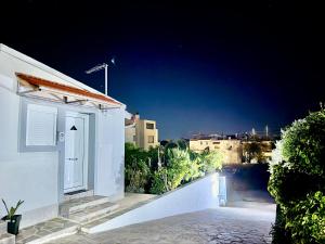 a white building with a door at night at The Wooden Nest in Asgourou