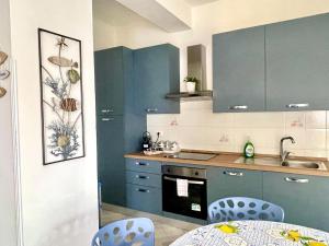a kitchen with blue cabinets and a table and chairs at Casa Cucchiara in Bagnara Calabra +17 photos